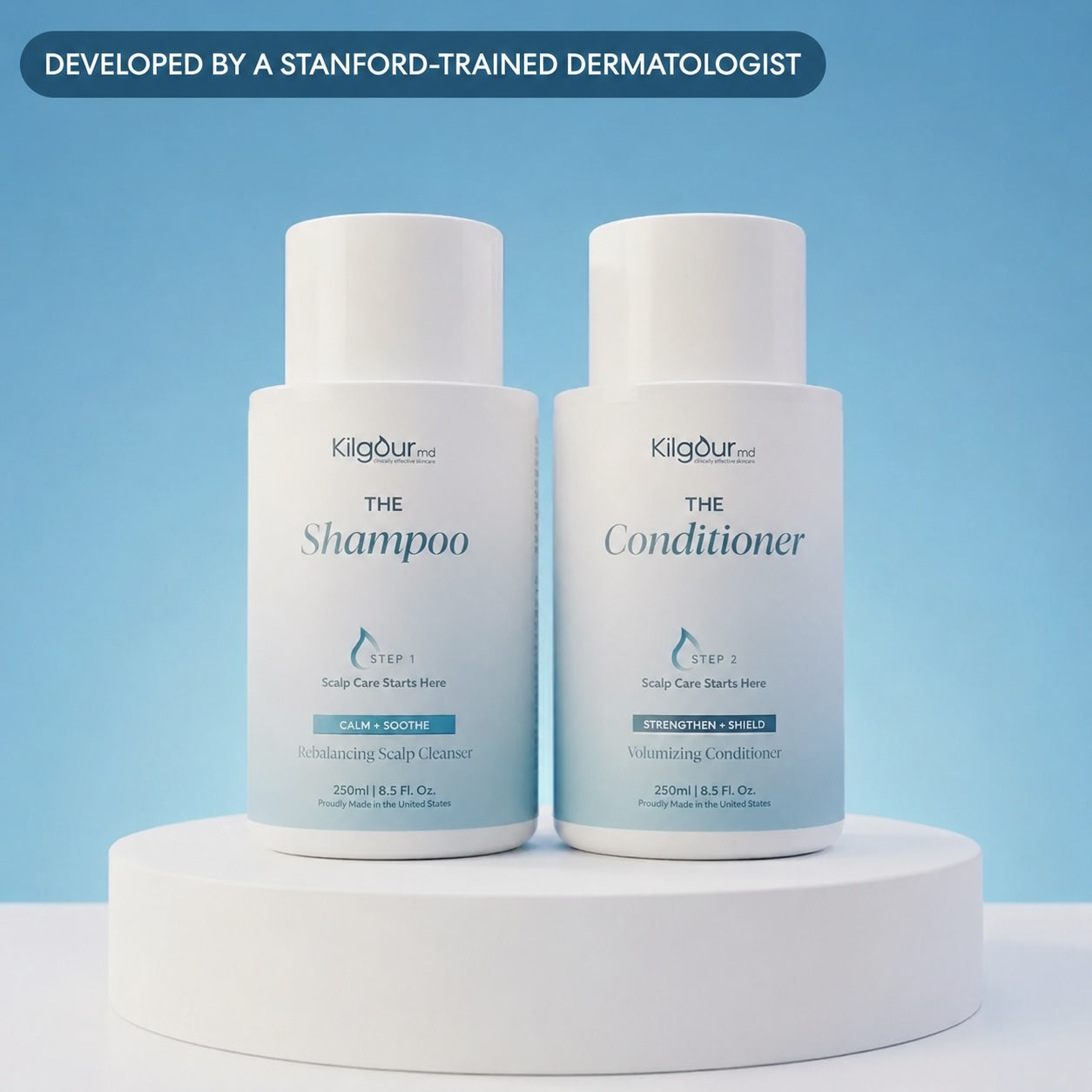 Front view of The Shampoo and Conditioner Bundle: two white KilgourMD bottles labeled The Shampoo and The Conditioner on a white pedestal against a light blue background with a ‘Developed by a Stanford-trained dermatologist’ banner
