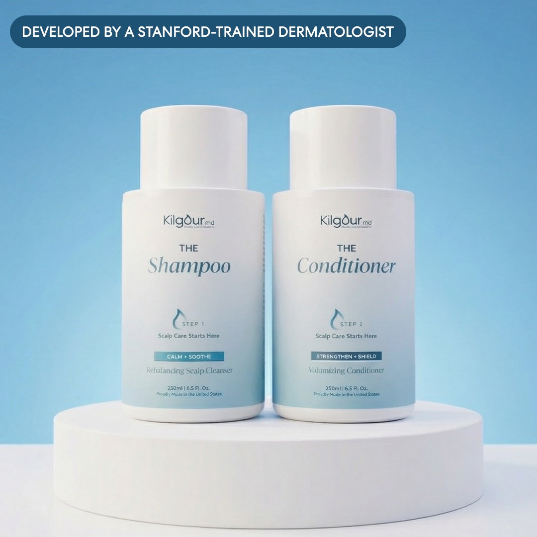 Two bottles of Kilgour shampoo and conditioner on a white platform with a blue background.